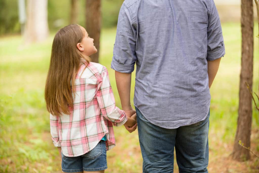 girl holding hands with father