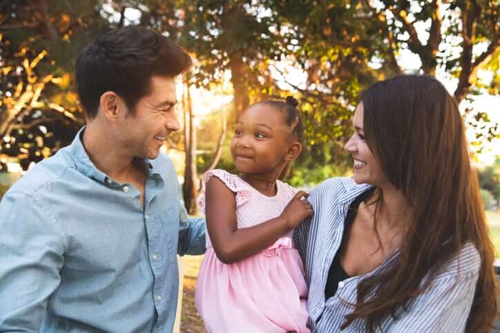 Multi racial family with adoptive children spending time together at the park